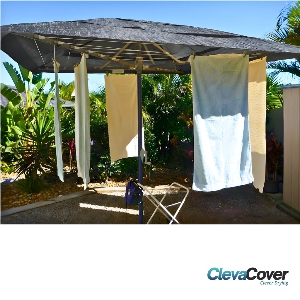 ClevaCover - Folding Rotary Clothesline with laundry hanging from it outside with a garden in the background. 